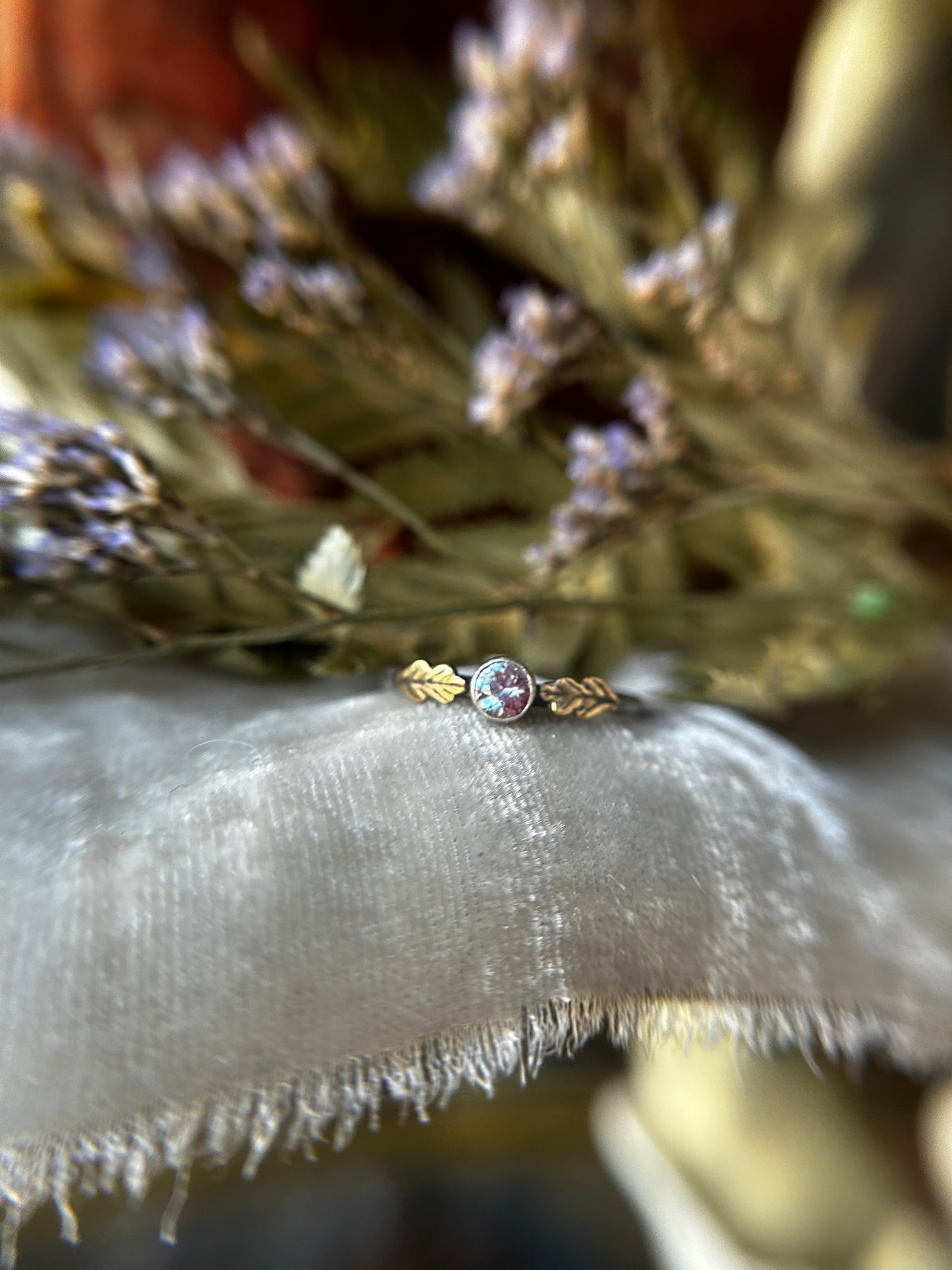 Close up of alexandrite ring option in brass oak leaves